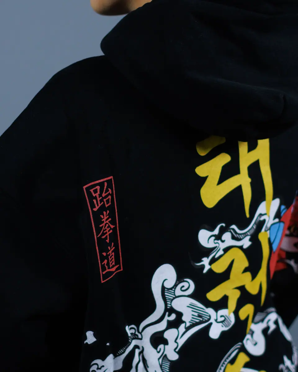 Close-up of a black hoodie printed in yellow, white and red